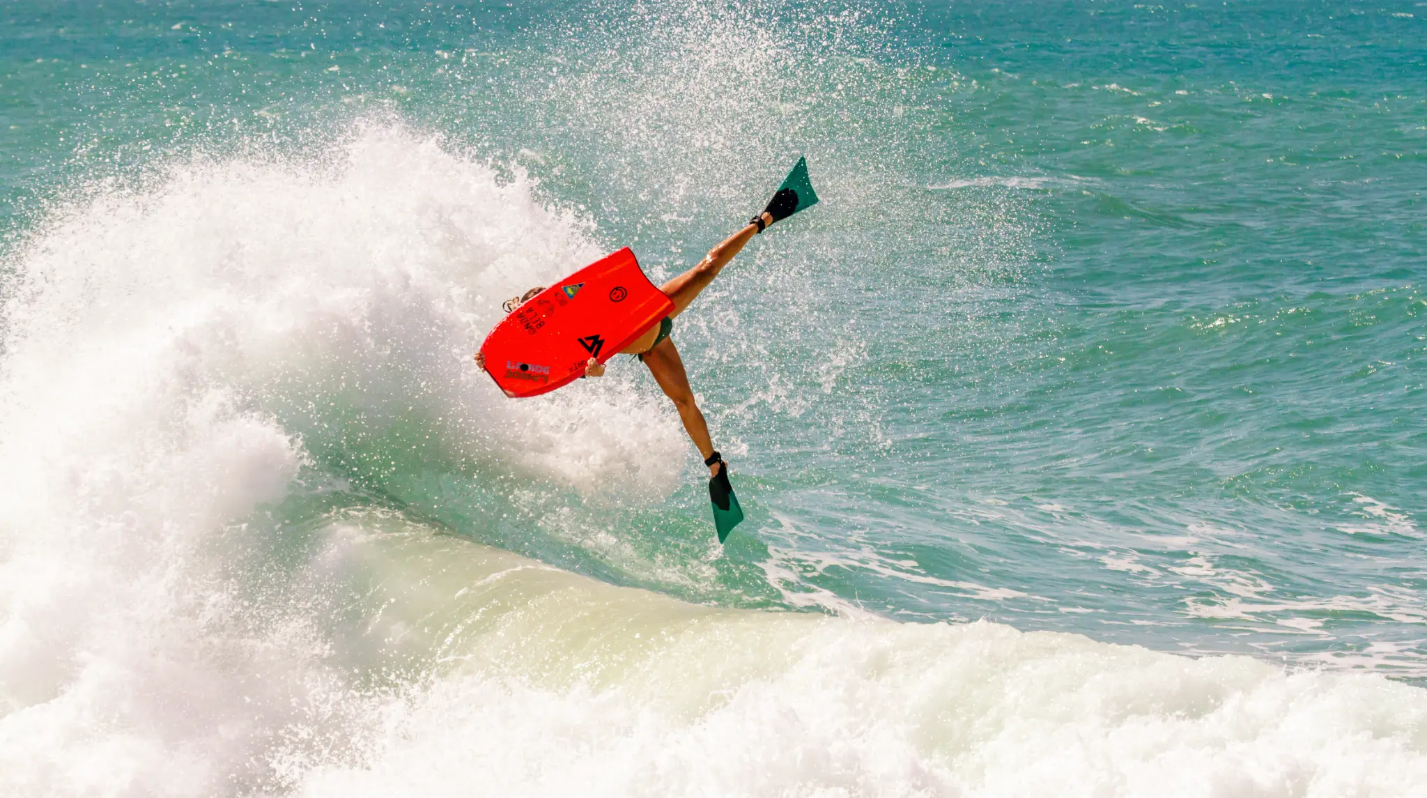 Isabela Sousa executando uma manobra de bodyboard sobre uma onda